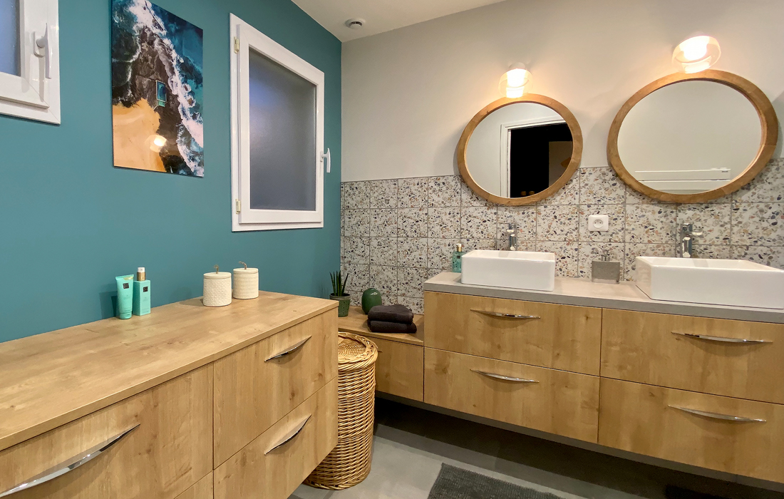 detail des meubles de la salle de bain de la chambre exotique avec un carrelage en effet béton du terrazzo et des touches de bois et de peinture bleu